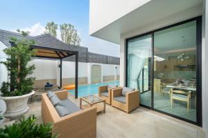 ein Wohnzimmer mit einem Pool und einem Haus in der Unterkunft Bangtao Brand New Luxury Modern Pool Villa Laguna Phuket in Thalang