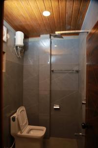 a small bathroom with a toilet and a shower at Marari Irine Homestay in Mararikulam
