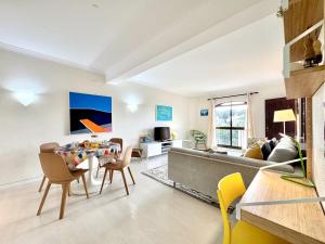 ヴィラモウラにあるVilmaoura Brightness Apartment 1 with Pool by Homingのソファとテーブルと椅子のあるリビングルーム