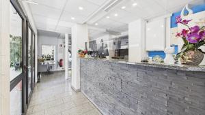 ルートヴィヒスブルクにあるシティ ホテルの花の飾られたレンガ造りのカウンターがあるロビー