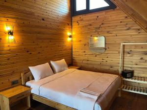 Un dormitorio con una cama en una pared de madera. en Yeşilköy Bungalovs, en Silifke
