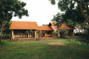 a house with an orange roof in a yard at Panai Adi Boutique Villa in Kuravankudil