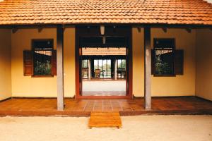 a house with a door and a wooden floor at Panai Adi Boutique Villa in Kuravankudil