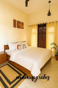 a bedroom with a large bed with white sheets at Vin's Villa & caffe in Bīr