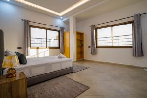 een slaapkamer met een groot bed en twee ramen bij Residence Fakir in Dakhla
