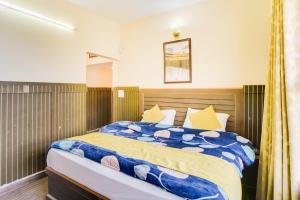 a bedroom with a bed with a blue and yellow comforter at Kasauli Residency in Kasauli