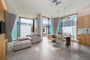 ein Wohnzimmer mit Tisch und Couch in der Unterkunft Bangtao Brand New Luxury Modern Pool Villa Laguna Phuket in Thalang
