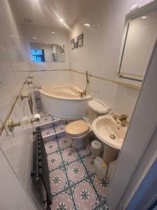 a bathroom with a tub and a toilet and a sink at Bayside - Breathtaking views of the Clyde in Rothesay +37 photos