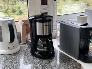 einem Mixer, der auf einer Theke neben einer Mikrowelle sitzt in der Unterkunft Green Valley Cruzinhas House with Fireplace & BBQ in Santana