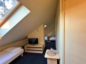 ボルネ・スリノボにあるNiron Marina Szalonego Grekaのベッド、デスク、テレビが備わる屋根裏部屋です。 +43枚の写真