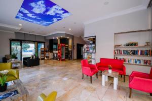 a living room with red chairs and bookshelves at Cleopatra King Apart in Alanya