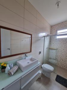 a bathroom with a sink and a toilet and a mirror at Apartment 202 Farol de Santa Marta in Laguna +9 photos