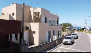a white car parked in front of a building at Apartment 202 Farol de Santa Marta in Laguna