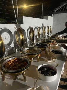a row of buffet tables filled with plates of food at 8 on Lorenzo in Amanzimtoti