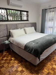 a large bed in a room with a couch at 8 on Lorenzo in Amanzimtoti