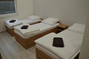 a room with three beds with white sheets at Ośrodek Sportu i Rekreacji w Janowcu Wielkopolskim in Janowiec Wielkopolski +15 photos