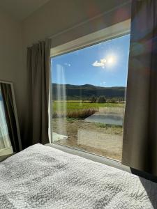 a bedroom with a window with a view of a field at Apartment in Målselv in Björklid