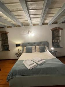 a bedroom with a large bed with two towels on it at Rota's House in Bergamo