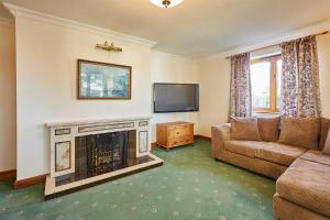 a living room with a couch and a fire place at Host & Stay - Cherry Willows in Stainsacre