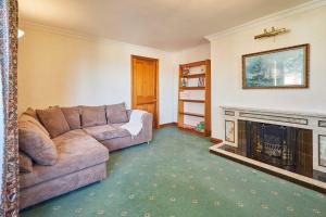 a living room with a couch and a fireplace at Host & Stay - Cherry Willows in Stainsacre