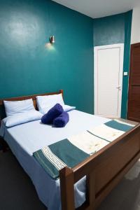 a bedroom with a large bed with blue walls at Spacious Coastal Home Steps from the Beach in Flic-en-Flac