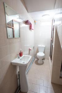 a white bathroom with a sink and a toilet at Spacious Coastal Home Steps from the Beach in Flic-en-Flac +19 photos