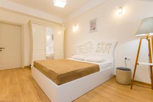 a white bedroom with a bed in a room at Central Elegant Apartment in Tbilisi City