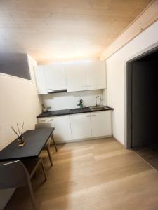 a small kitchen with white cabinets and a table at Appartamento vacanze Piazza in Fondo +12 photos