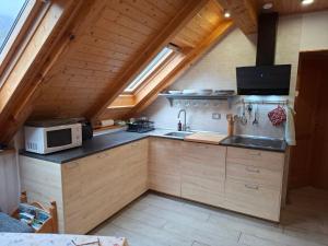 an attic kitchen with a sink and a microwave at APARTMA ANA IDA in Srpenica