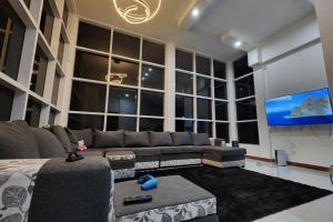 a living room with a couch and a flat screen tv at 5 Bed Villa Sleeps 10 with Jacuzzi in Georgetown