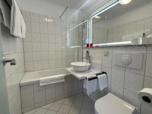 a white bathroom with a sink and a toilet at DORMERO Hotel Weimar in Weimar +18 photos