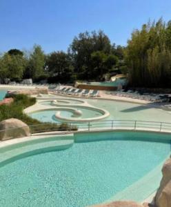 a large swimming pool with chairs in a resort at Spacieux T2 Superbe vue mer in Grimaud