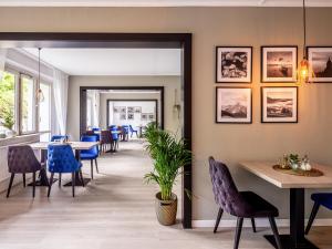a dining room with blue chairs and tables at DORMERO Hotel Weimar in Weimar