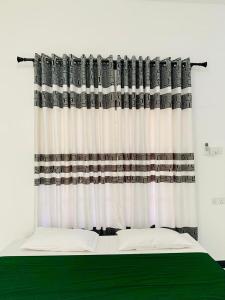 a bedroom with a bed and a curtain at Wilpattu Nuga Lodge in Pahala Maragahawewa