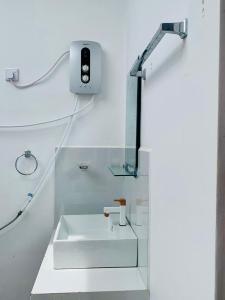 a white bathroom with a sink and a mirror at Wilpattu Nuga Lodge in Pahala Maragahawewa
