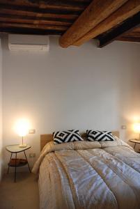 1 dormitorio con 1 cama con 2 almohadas y mesa en S. Agostino Fronte Mura, en Lucca