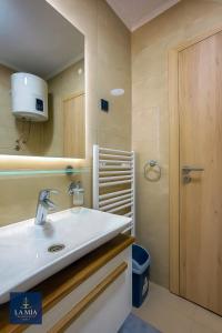 een badkamer met een wastafel en een spiegel bij La Mia Premium Suite in Tuzla