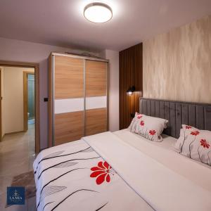 een slaapkamer met een groot bed met rode bloemen erop bij La Mia Premium Suite in Tuzla