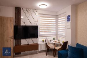 een woonkamer met een televisie en een tafel bij La Mia Premium Suite in Tuzla