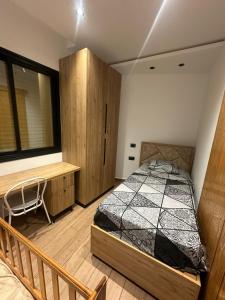 une chambre avec un lit et une armoire en bois dans l'établissement Immobilier hammamet nord, à Hammamet