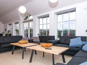 a living room with couches and tables and windows at 16 person holiday home in Ulfborg in Ulfborg