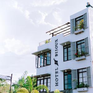 a white building with black shutters and plants on it at Hotel Bijoux in Plaridel
