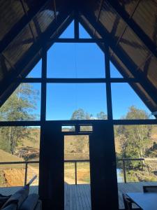 ItaquáにあるChalé de alto padrão Nereuの大きな窓が備わる建物の内側からの景色を望めます。