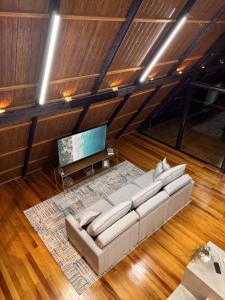 ItaquáにあるChalé de alto padrão Nereuのリビングルーム(白いソファ、テレビ付)