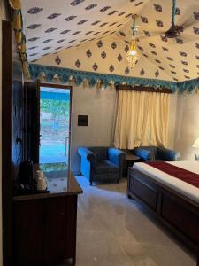 a hotel room with a bed and a living room at Estherea Bagh Ranthambhore Tiger Territory in Sawāi Mādhopur +6 photos