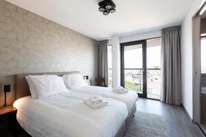 ein Schlafzimmer mit einem großen weißen Bett mit Handtüchern darauf in der Unterkunft Droomsuites Egmond aan Zee 8 personen by Droomvilla in Egmond aan Zee