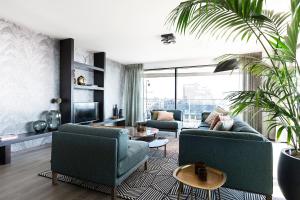 ein Wohnzimmer mit zwei Sofas und einem Fernseher in der Unterkunft Droomsuites Egmond aan Zee 8 personen by Droomvilla in Egmond aan Zee