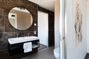 ein Badezimmer mit Waschbecken und Spiegel in der Unterkunft Droomsuites Egmond aan Zee 8 personen by Droomvilla in Egmond aan Zee + 19 Fotos