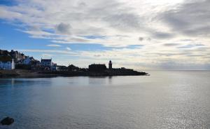 - une vue sur une étendue d'eau avec un phare dans l'établissement Crown hotel, à Portpatrick