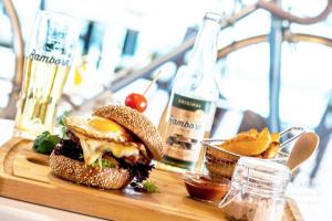 ベルドルフにあるTrail-Inn Natur & Sporthotelのまな板の上にサンドイッチとチップス、そしてワインのボトル